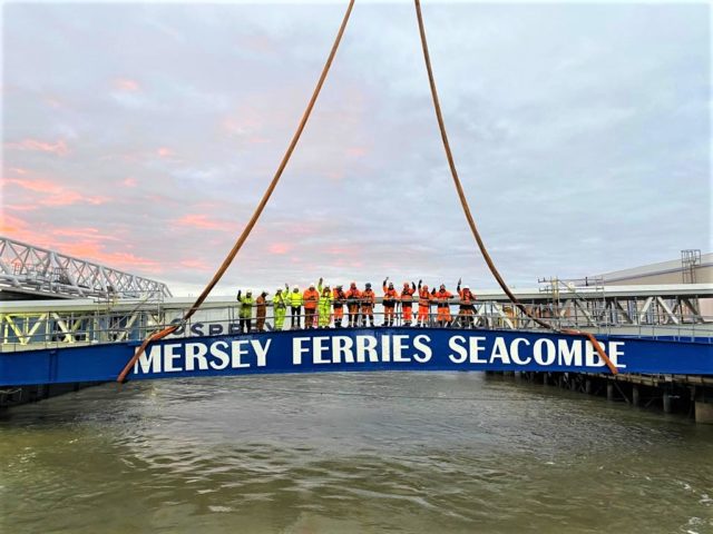 Osprey team stood on Seacombe Ferry Terminal waving