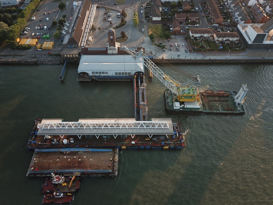 Aerial view of the Mersey Ferry Terminal , with floating crane barge removing sections of it.